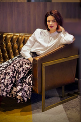 a lady in a white shirt and a floral printed skirt